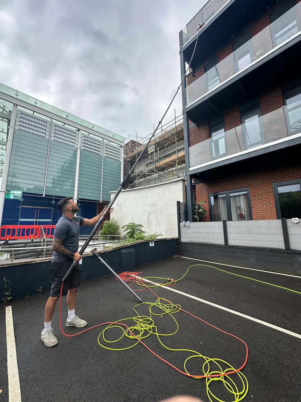 Water-fed pole brush cleaning the exterior trim and frame of a house