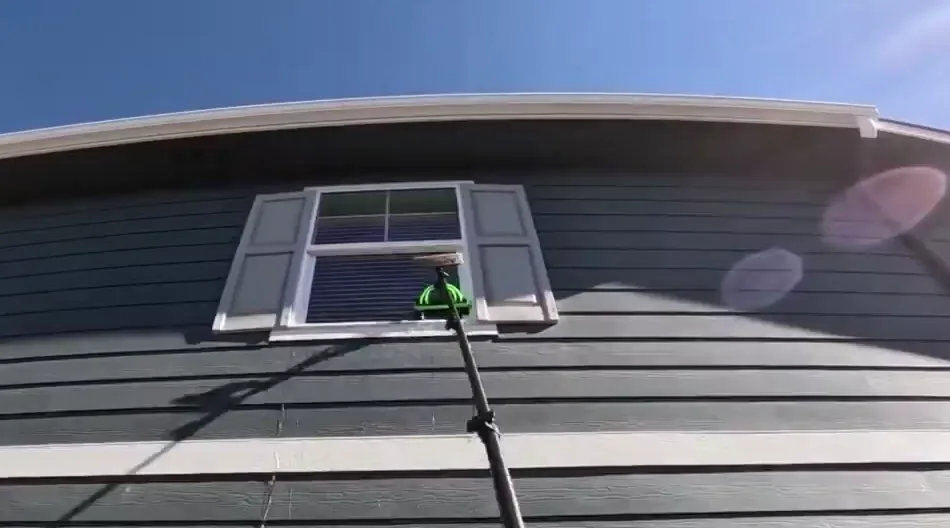 Water-fed pole and brush actively cleaning an upper-floor window