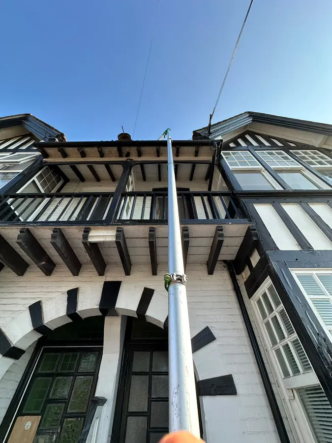Gutter vacuum reaching a striking black-and-white timbered building