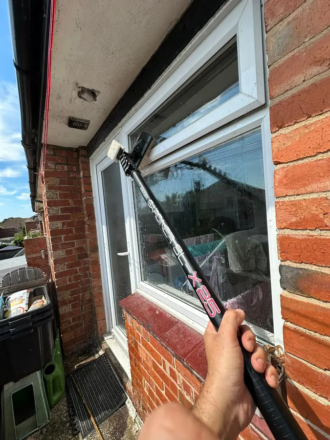 Close-up of a window being scrubbed with the water-fed brush
